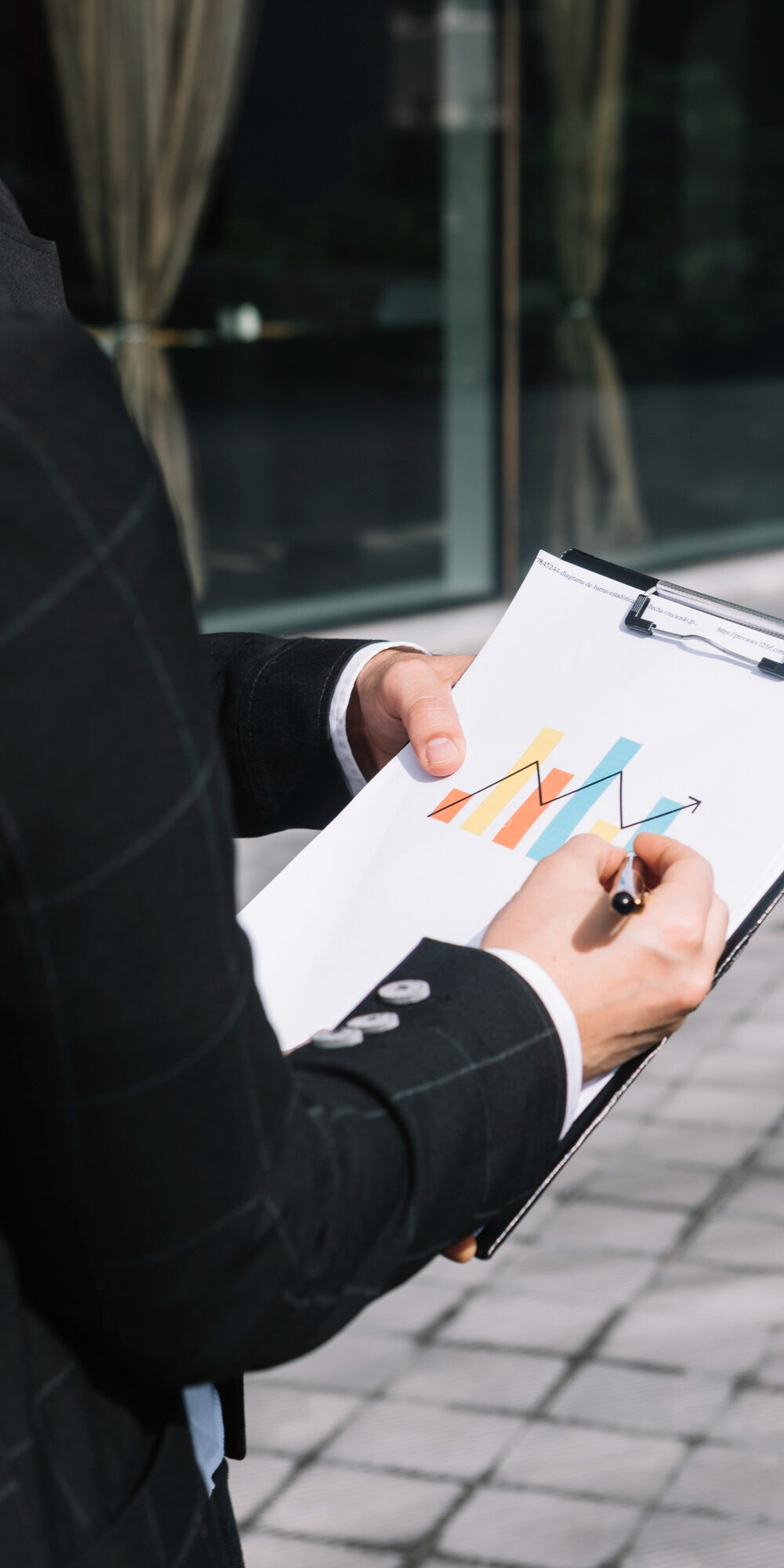 close-up-business-person-s-hand-drawing-increasing-arrow-graph-clipboard